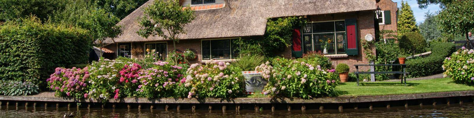 Huis met rieten dak aan water